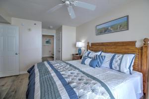 a bedroom with a bed and a ceiling fan at Crescent Shores North - 1502 in Myrtle Beach +31 photos