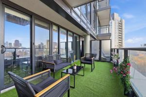 an apartment patio with chairs and tables and windows at Bright Downtown Condo with City Views & Comfort in Toronto