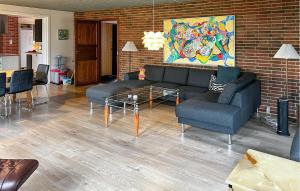 a living room with a couch and chairs and a brick wall at Hellehave in Ravnholt