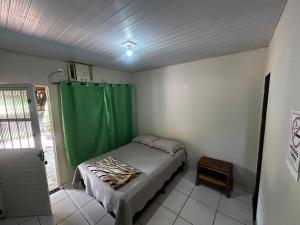 诺布里斯Pousada São Martins的一间小卧室,配有床和绿帘