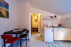 eine Küche mit Tisch und eine kleine Küche mit Tisch und Stühlen in der Unterkunft Apartments with parking space Trpanj, Peljesac - 257 in Trpanj