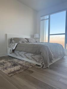 Dormitorio blanco con cama con manta de cebra en The greatest views in the heart of Mississauga, en Mississauga