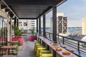 オークランドにあるJO&JOE Aucklandの建物の上にテーブルと椅子が置かれたバルコニー