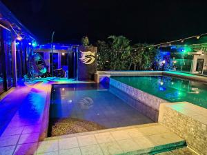 a swimming pool at night with blue and purple lights at 8 dragon resort standard rooms in Silang
