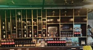 a shelf filled with lots of bottles of wine at 8 dragon resort standard rooms in Silang