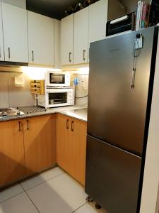 马尼拉McKinley Hills BGC Taguig City Condo的厨房配有不锈钢冰箱和微波炉。