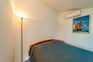 a small bedroom with a bed and a lamp at Studio Trpanj 257c in Trpanj