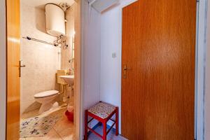 Un baño con inodoro y puerta de madera. en Studio Trpanj 257c, en Trpanj