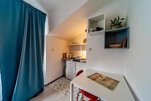 una pequeña cocina con una mesa y una cortina azul en Studio Trpanj 257c, en Trpanj 9 fotos más