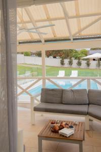 a living room with a couch and a table and a pool at Illaroo House in Shoal Bay