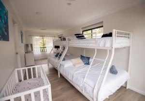 a bedroom with two bunk beds in a room at Illaroo House in Shoal Bay +41 photos