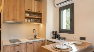 a kitchen with wooden cabinets and a sink and a window at NAMA Suites in Hersonissos