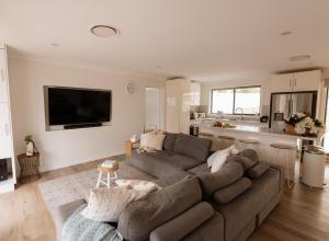 a living room with a couch and a kitchen at Illaroo House in Shoal Bay