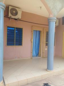 KikaGhi House的一间有两根柱子和一台风扇的房间