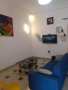 KikaGhi House的客厅里有一张蓝色的沙发和一张桌子