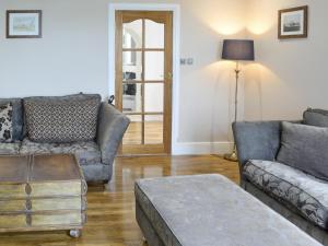 a living room with two couches and a table at The View Old Coastguard Cottage in Tynemouth