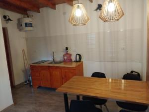 cocina con mesa de madera y 2 luces en Departamento Rojavitiva, en General Belgrano