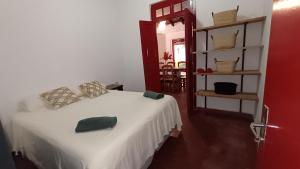 ein Schlafzimmer mit einem weißen Bett und einer roten Tür in der Unterkunft Casa Angela María in Caacupé
