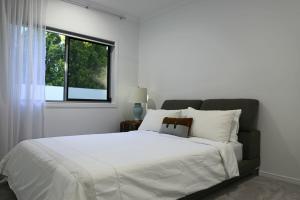 Un dormitorio con una gran cama blanca con ventana. en Serenade Retreat, At Coomera Waters, Gold Coast, en Gold Coast 55 fotos más