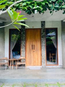 Casa con puerta de madera, mesa y sillas en Cozy Room W Villa in uluwatu by d'ulu villa, en Uluwatu