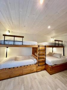 two bunk beds in a room with a ceiling at Hotel Casa Surf in Pichilemu