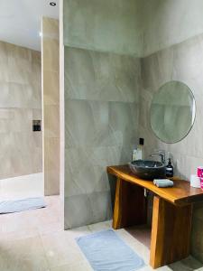 un baño con lavabo y espejo en Cozy Room W Villa in uluwatu by d'ulu villa, en Uluwatu
