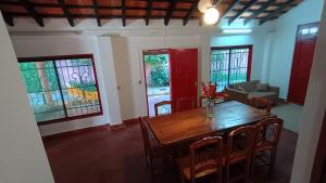 ein Esszimmer mit einem Tisch, Stühlen und Buntglasfenstern in der Unterkunft Casa Angela María in Caacupé