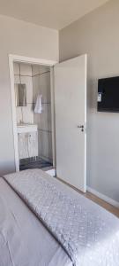 a bedroom with a large white bed with a door at Suite Master Bella in São José