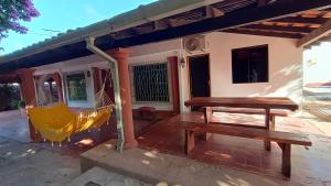eine Veranda mit einer Bank und einer Hängematte auf einem Haus in der Unterkunft Casa Angela María in Caacupé