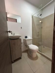 a bathroom with a toilet and a sink and a shower at Apartamento Roldanillo in Roldanillo