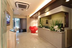 a lobby with a reception desk and a red chair at HOTEL DCUBE in Tokyo +22 photos