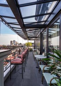 a balcony with tables and chairs on a building at La Mejor Indochine Hotel in Hanoi