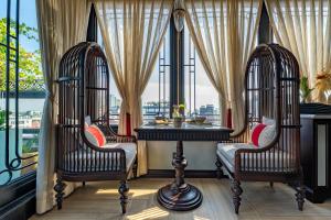 a restaurant with two chairs and a table in a window at La Mejor Indochine Hotel in Hanoi