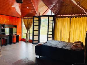 a bedroom with a bed and a television in a room at Cabaña Viento Sereno in Tibaná