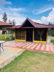 a house with a brick patio in front of it at Cabaña Viento Sereno in Tibaná +7 photos
