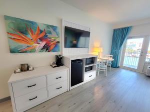 ein Wohnzimmer mit einem weißen Schrank und einem Fernseher in der Unterkunft ChartHouse Clearwater Beach Marina Hotel in Clearwater Beach