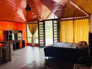 a bedroom with a bed and a large window at Cabaña Viento Sereno in Tibaná