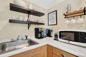 a kitchen with a sink and a microwave at Above the Tea Room off Madison Square in Savannah