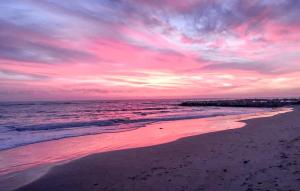 a sunset on a beach with the ocean at Villa Magnolia in Grosseto +16 photos
