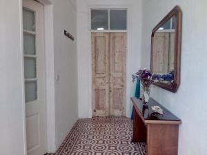 a hallway with a mirror and a table and a door at Casa Almirante Reis in Olhão