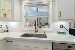 a white kitchen with a sink and a window at Spacious 5BR Retreat with Private Suite Sleeps 12 in Mississauga +40 photos