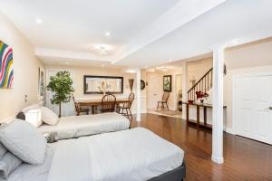 a living room with two beds and a table at Spacious 5BR Retreat with Private Suite Sleeps 12 in Mississauga