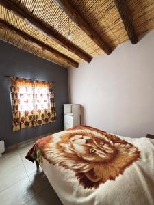 a bedroom with a bed with a tiger blanket on it at Alojamiento Tati in Purmamarca