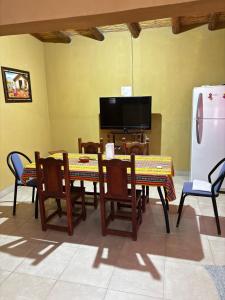 a living room with tables and chairs and a tv at Alojamiento Tati in Purmamarca