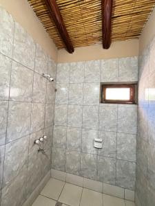 a bathroom with a shower with a tiled wall at Alojamiento Tati in Purmamarca