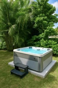 a hot tub sitting in the grass in a yard at Steps To Beach! 4 Condos In 1- Perfect For Groups in West Palm Beach
