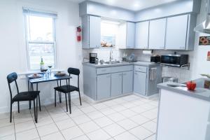 una cucina con mobili bianchi, tavolo e sedie di EconoPod 6 a River Rouge Altre 19 foto
