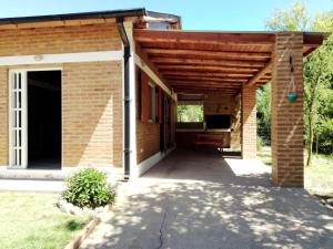 a brick pavilion with a wooden roof at Aguaribay Cabañas in Arroyo de Los Patos
