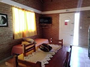 a bedroom with two beds and a window and a table at Aguaribay Cabañas in Arroyo de Los Patos