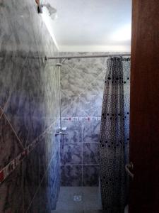 a bathroom with a shower with a shower curtain at Aguaribay Cabañas in Arroyo de Los Patos +24 photos